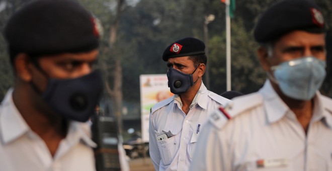 Policías de tráfico para protegerse del humo y del polvo en Nueva Delhi.. REUTERS/Anushree Fadnavis