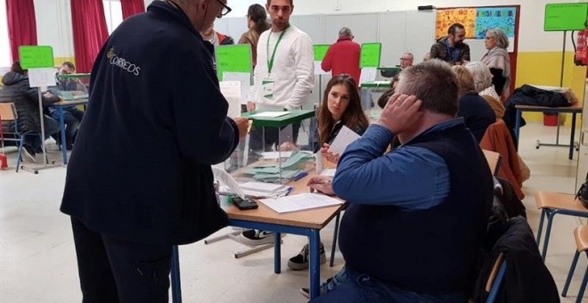 02/12/2018.- Un funcionario entrega votos que han llegado por correos y deben estar en la mesa electoral hasta que se abran, en el colegio Sor Ángela de la Cruz del distrito Macarena, en Sevilla, hoy en la jornada de los undécimos comicios autonómicos and