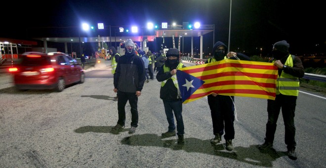 Un grupo de los Comités de Defensa de la República (CDR) levantan las barreras en la salida de la AP-7. / EFE