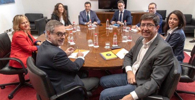 Los equipos negociadores de Partido Popular y Ciudadanos, encabezados por Juanma Moreno (c) y Juan Marín (2d) al comienzo de la segunda reunión en el Parlamento andaluz en Sevilla para tratar sobre el cambio de Gobierno en Andalucía. EFE/Julio Muñoz