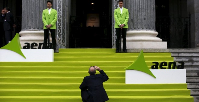 Un hombre saca una foto con su móvil en la entrada de la Bolsa de Madrid, el día en que Aena comenzó a cotizar en el mercado, en febrero de 2015. REUTERS