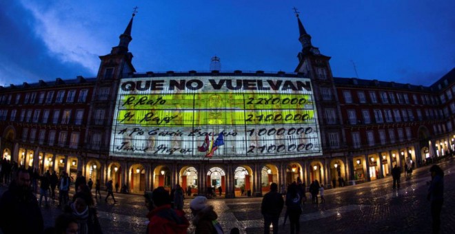 La fachada de la Casa de la Panadería de la Plaza Mayor de Madrid se ha iluminado esta noche con imágenes de gran formato de los conocidos como 'papeles de Bárcenas', donde aparecen los nombres de 'M. Rajoy' o 'R. Rato', y otra con Pedro Sánchez y Albert