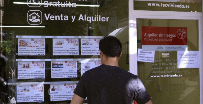 Un hombre mirando un escaparate de pisos. EFE