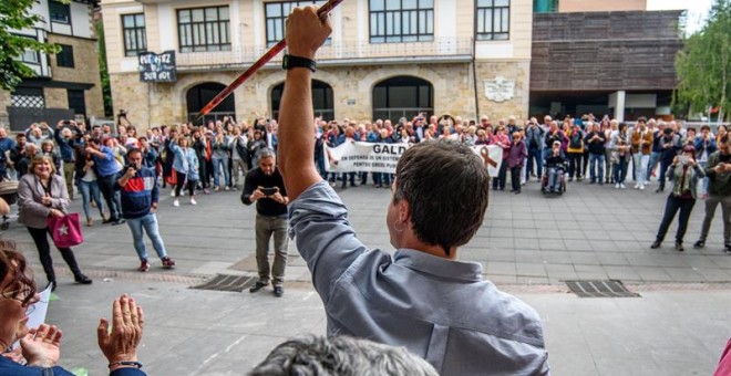 Pleno de constitución del Ayuntamiento de Galdakao. El nuevo alcalde Iñigo Hernando(c) de EH Bildu saluda con la makila, bastón de mando, a los simpatizantes que esperaban fuera del ayuntamiento. EFE/JAVIER ZORRILLA