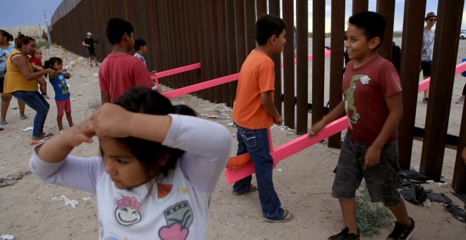 Los niños mexicanos se divierten en la frontera mientras juegan con niños norteamericanos, situados al otro lado de la valla. LUIS TORRES (AFP).