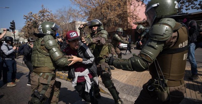 Carabineros detienen a un manifestante en Santiago de Chile, en la tradicional romería hacia el Cementerio General, en memoria de las víctimas de la dictadura de Augusto Pinochet. /EFE