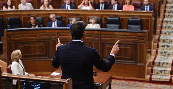 El presidente del Gobierno en funciones, Pedro Sánchez (de espaldas), responde al líder del PP, Pablo Casado, durante la segunda y última sesión de control de esta legislatura celebrada este miércoles en el hemiciclo del Congreso. EFE/Fernando Villar