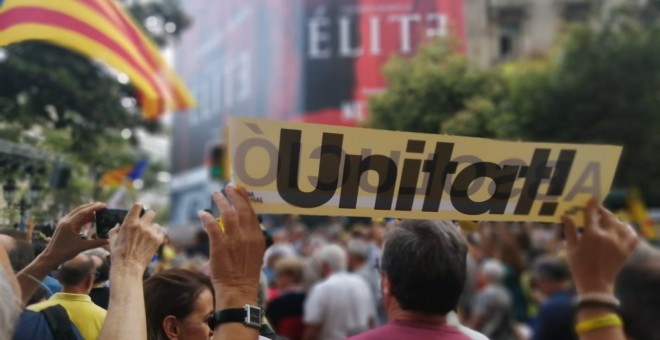 Un manifestant aixeca un cartell on posa 'unitat!' repartit per membres de la Crida per la República durant la manifestació del segon aniversari dels escorcolls a la seu del Departament d'Economia. Ander Zurimendi