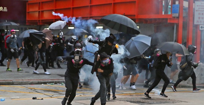 Los manifestantes antigubernamentales huyeron del gas lacrimógeno durante las protestas en el Día Nacional en Hong Kong, China.EFE / EPA / FAZRY ISMAIL