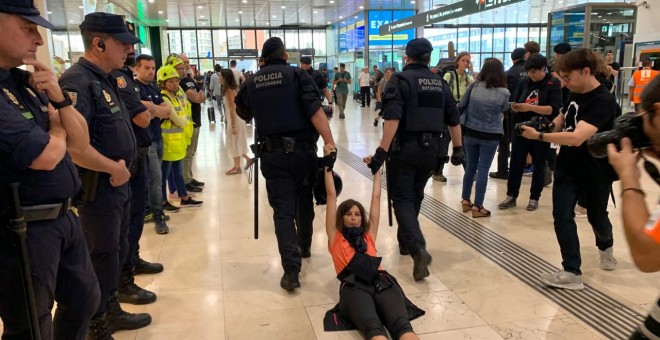 Dos mossos arrosseguen una activista dels CDR que formava part del bloqueig a l'Estació de Sants aquest diumenge al matí. Marià de Delàs