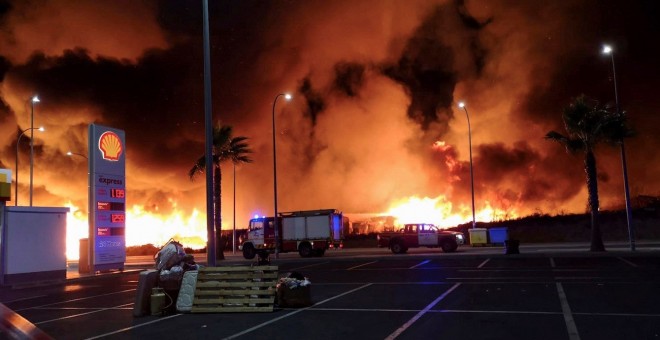 14/10/2019 - Imagen de las llamas producidas por el incendio que se ha originado poco antes de las diez de la noche en el asentamiento de inmigrantes ubicado junto al cementerio de Lepe, y que ha obligado a desalojarlo por completo. EFE/Julián Pérez.