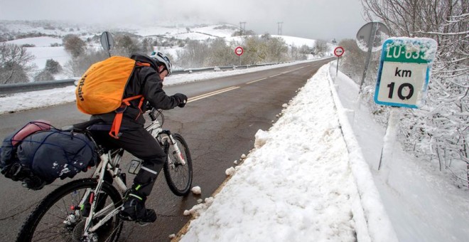 Un peregrino de Valladolid circula con su bicicleta por el kilómetro 10 de la carretera LU-663. EFE/Eliseo Trigo