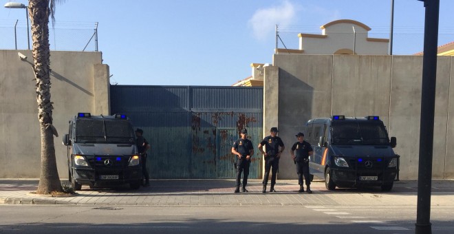 Fachada del CIE custodiada por dos policías, antes de empezar una manifestación.