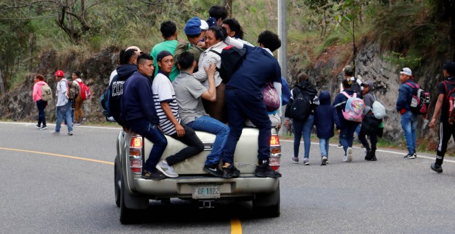 Uno de los migrantes durmiendo arropado por la bandera de Honduras. / Reuters