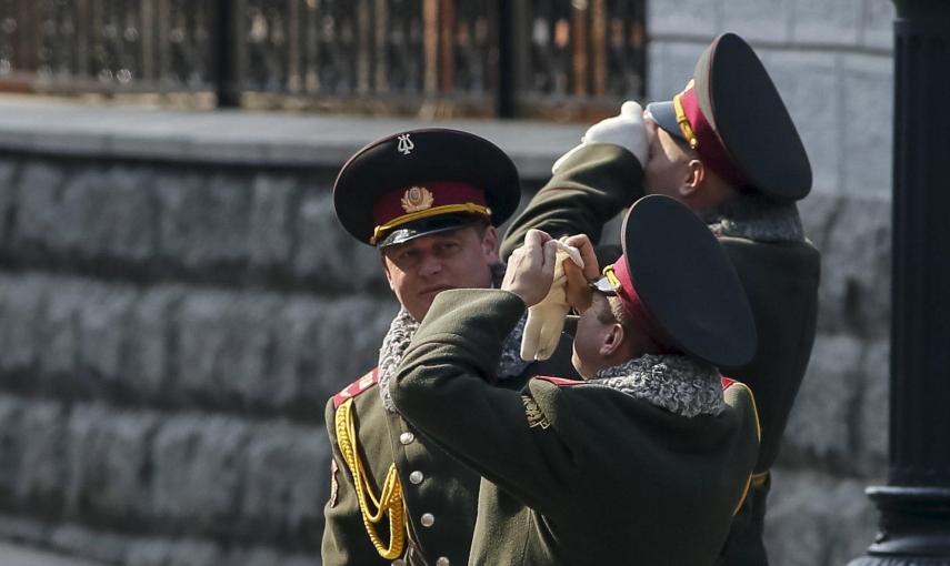 Miembros de la banda de música militar del Ejército ucraniano observan el eclipse parcial de sol en Kiev. REUTERS/Gleb Garanich