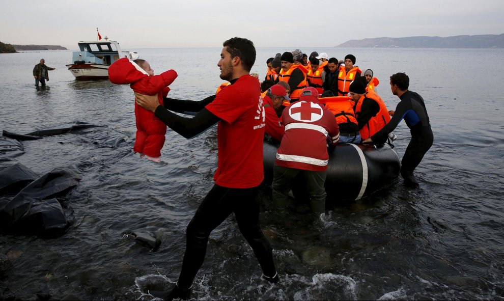 Un voluntario coge a un bebé refugiado en la playa de la isla griega de Lesbos. REUTERS/Yannis Behrakis