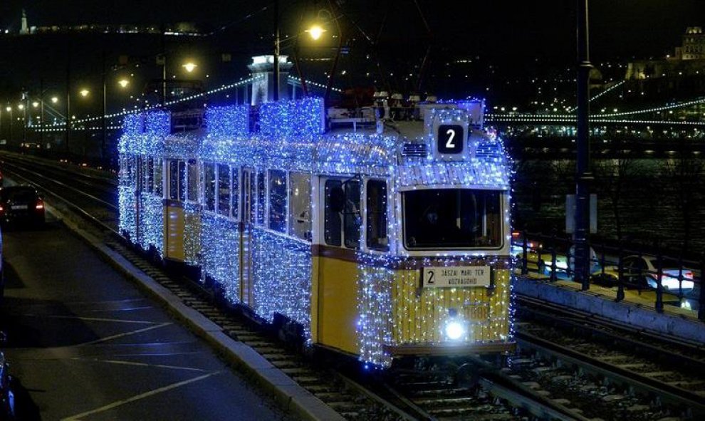 Vista de un tranvía decorado con luces navideñas cerca del Danubio y con el Puente de las Cadenas iluminado en el fondo. Budapest, Hungría. EFE/Zoltan Mathe