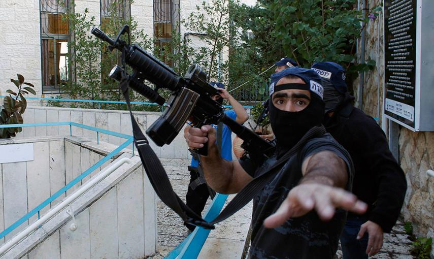 Un policía israelí gesticula mientras sostiene un arma cerca de la escena de un ataque a una sinagoga en Jerusalén. // RONEN ZVULUN (REUTERS)