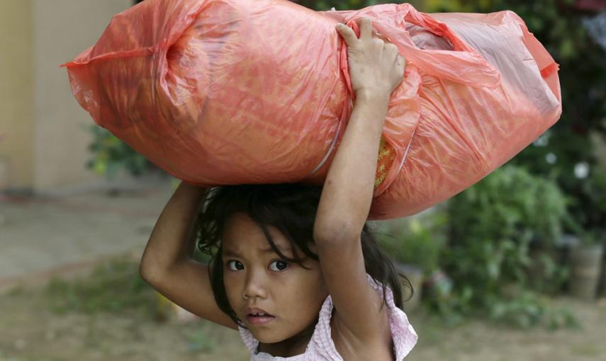 Una niña filipina cargada con sus pertenencias, camina hacia el centro de refugiados en Manila. // EFE/EPA/DENNIS M. SABANGAN