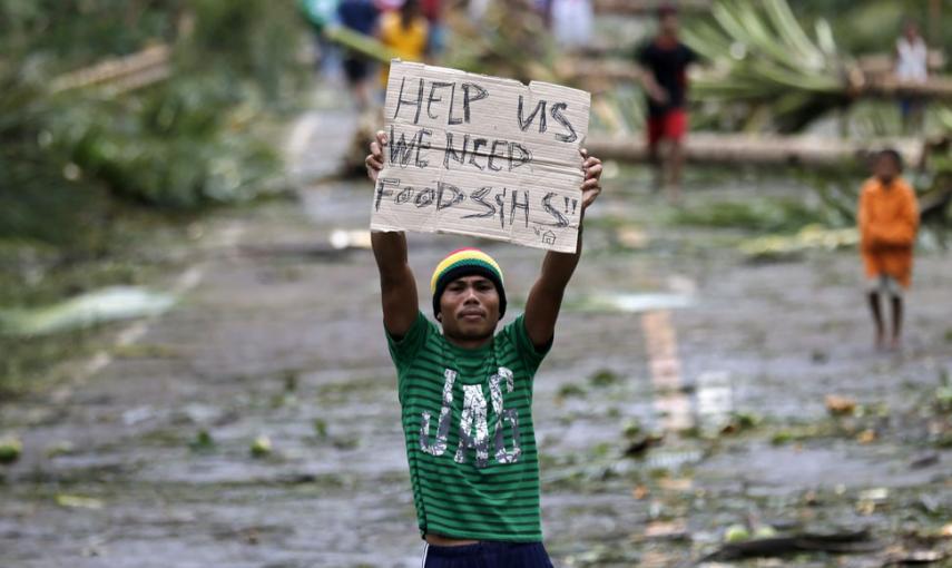 Un filipino con un cartel reclamando ayuda para las víctimas del tifón Hagupit, en la ciudad Taft, en la isla de Samar. // EFE/EPA/FRANCIS R. MALASIG