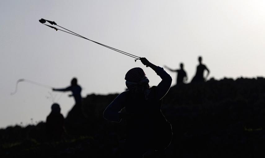 Manifestantes palestinos utilizan hondas para lanzar piedras a los soldados israelíes durante los enfrentamientos cerca de la ciudad cisjordana de Ramala. /MOHAMAD TOROKMAN (REUTERS)