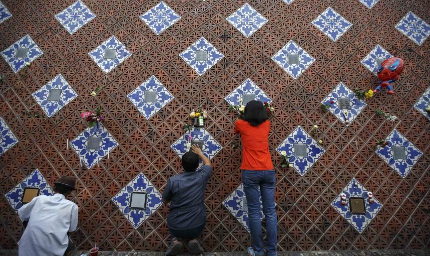 Un grupo de familiares colocan flores en el monumento en recuerdo de las víctimas del tsunami en la aldea costera de Ban Nam Khem, al sur de Tailandia. REUTERS/Athit Perawongmetha