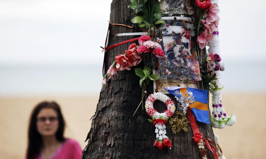 Una mujer observa el arbol decorado con fotos, flores y cintas, en recuerdo de los turistas suecos que murieron por el tsunami de 2004, en las playas de Khao Lak en Tailandia. REUTERS/Athit Perawongmetha