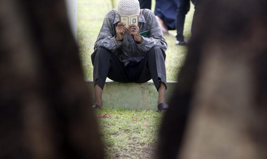 Un hombre reza en una fosa común de víctimas del tsunami en Banda Aceh (Indonesia). EFE/Adi Weda