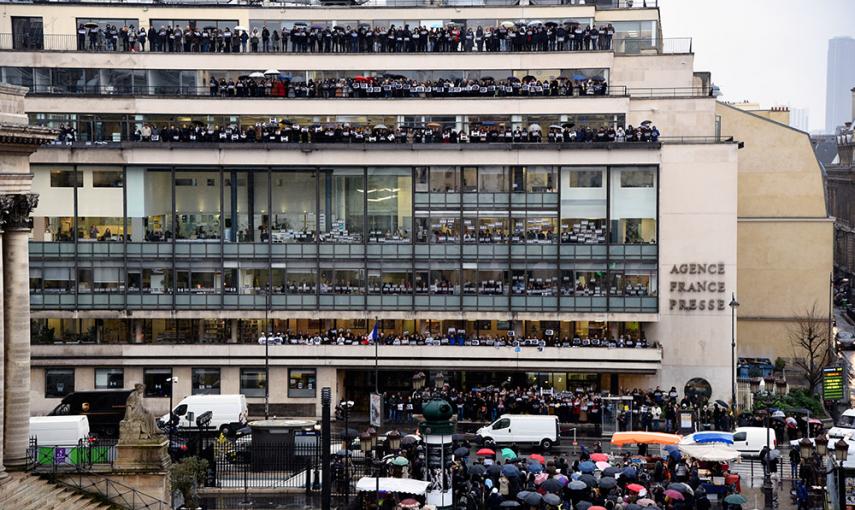 Periodistas de la agencia de prensa internacional France Presse posan ante su sede con carteles con la inscripción "Je suis Charlie", mientras guardan un minuto de silencio por las víctimas del atentado terrorista en el semanario satírico 'Charlie Ebdo'.