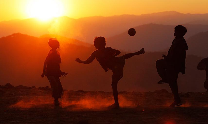 Unos niños juegan con una pelota al atardecer en el pueblo de Yansi, en el noroeste de Myanmar. /SOE ZEYA TUN (REUTERS)