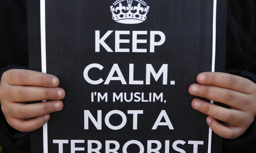 A girl holds a sign during a rally by members of the Muslim community of Madrid outside Madrid's Atocha train station, January 11, 2015, in solidarity with the victims of a shooting by gunmen at the Paris offices of the satirical weekly newspaper Charlie