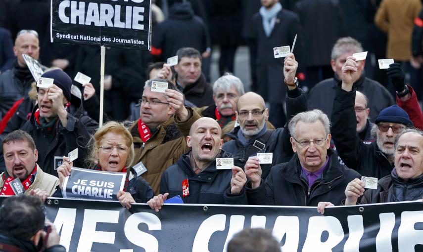 French journalists holding up their Press card take part in a hundreds of thousands of French citizens solidarity march (Marche Republicaine) in the streets of Paris January 11, 2015. French citizens will be joined by dozens of foreign leaders, among them