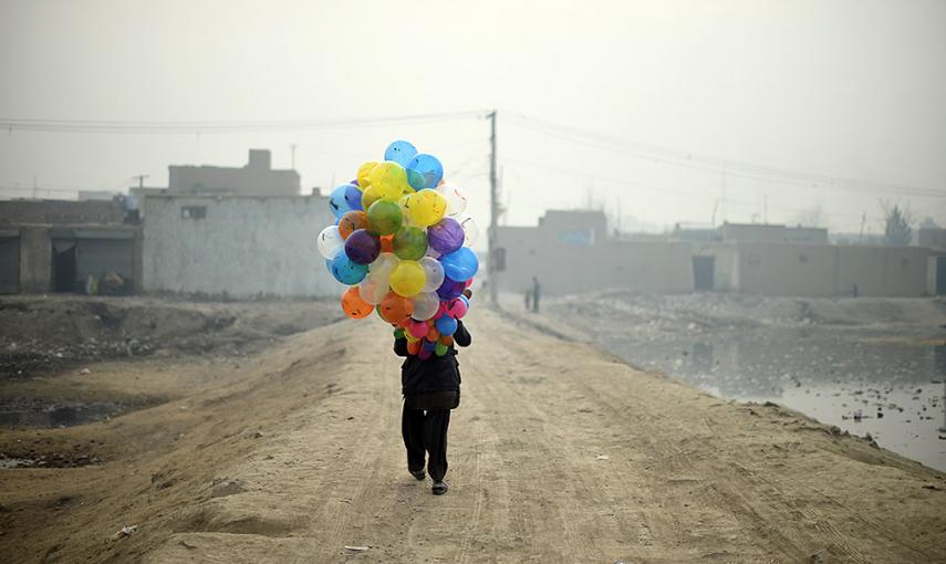 Un vendedor de globos afgano de 19 años busca clientes en un barrio de Kabul. /SHAH MARAI (AFP)