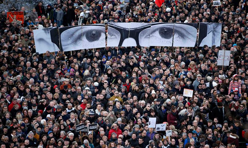 Manifestantes recrean con varios paneles los ojos del editor de Charlie Ebdo, Stephane Charbonnier, 'Charb', durante una marcha solidaria en las Calles de París. /YVES HERMAN (REUTERS)