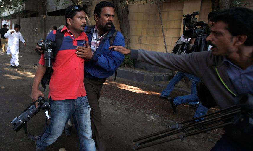 Un fotógrafo de France-Presse, es ayudado por varios compañeros tras recibir un disparo durante una protesta en Karachi (Pakistán) durante una violenta protesta contra el semanario Charlie Ebdo. /AKHTAR SOOMRO (REUTERS)