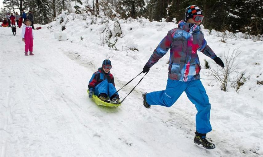 Dos jóvenes se divierten con su trineo en el Alto de Erro (Navarra) que esta mañana ha amanecido nevado debido al temporal de frío y nieve que azota el norte de la comunidad Foral. EFE/Villar López