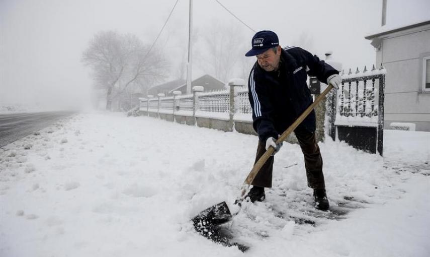 Un hombre retira la nieve con una pala en la entrada de su casa en la localidad ourensana de Casetas de Rodicio (Maceda) que amanecía hoy nevado debido al temporal de frío y viento que afecta a Galicia y gran parte de la península. EFE/Brais Lorenzo