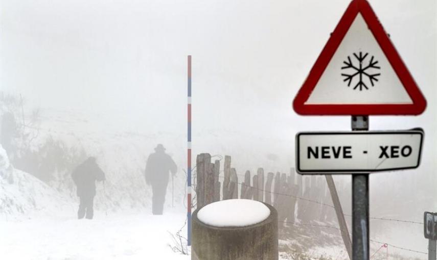 Dos personas suben a pie al albergue de los Ancares y Tres Obispos (Lugo) que permanecía hoy cubierto de nieve debido al temporal de frío que afecta a Galicia y gran parte de la península. EFE/Eliseo Trigo