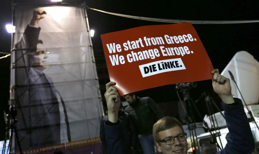 Un seguidor de Syriza en el exterior de la sede de la campaña electoral del partido de Alwexis Tsipras, celebra los resultados de las elecciones adelantados por los sondeos a pie de urna. REUTERS/Marko Djurica