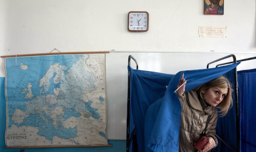 Una mujer sale de la cabina electoral en Salónica para depositar su voto en las elecciones griegas. REUTERS/Alexandros Avramidis