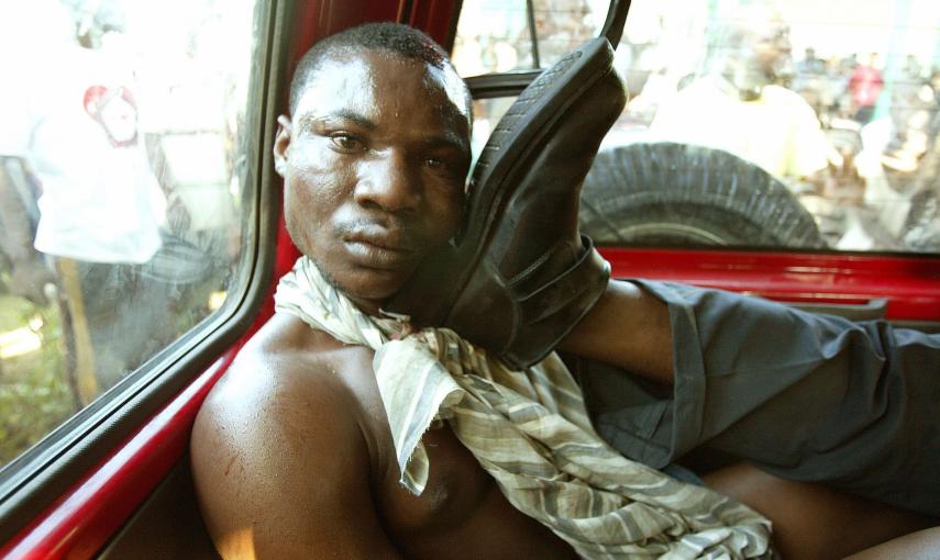 Un haitiano sospechoso de ser un asesino múltiple para el partido Lavalas del presidente exiliado Jean Bertrand Aristide, detenido en Petit Goave y posteriormente lapidado y quemado vivo (3 de marzo de 2004). REUTERS / Daniel Aguilar