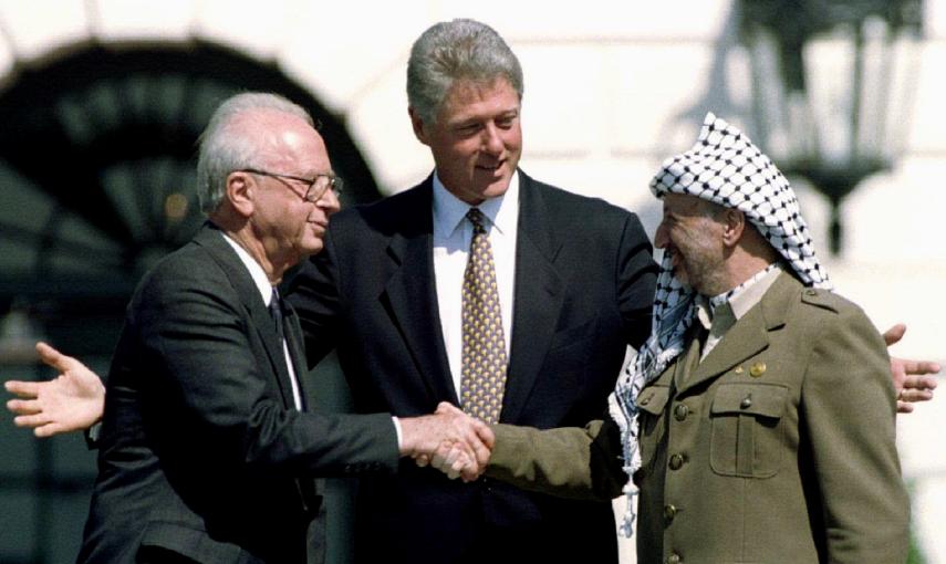 El presidente de EEUU, Bill Clinton, observa mientras el primer ministro israelí Isaac Rabin y el líder de la Organización de Liberación de Palestina (OLP),  Yasser Arafat, se dan la mano después de la firma de del acuerdo de paz en la Casa Blanca (13 de