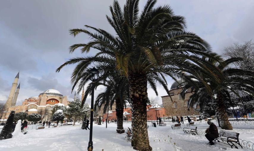 Un turista se sienta en un banco en la Plaza de la Mezquita cubierta por un gran manto blanco en el centro histórico de la ciudad de Estambul./REUTERS-Murad Sezer