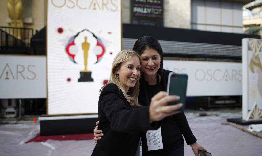 Dos mujeres se hacen un selfie junto a uno de los carteles anunciadores de la 87ª gala de entrega de los premios Oscan en  el Dolby Theater de Los Ángeles. REUTERS/Lucy Nicholson