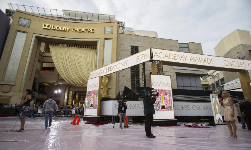 Varios reporteros de televisión situados sobre la alfombra roja junto al  Dolby Theater de Los Ángeles donde se celebrará la gala de entrega de los 87ª premios Oscar de Hollywood. REUTERS/Mario Anzuoni