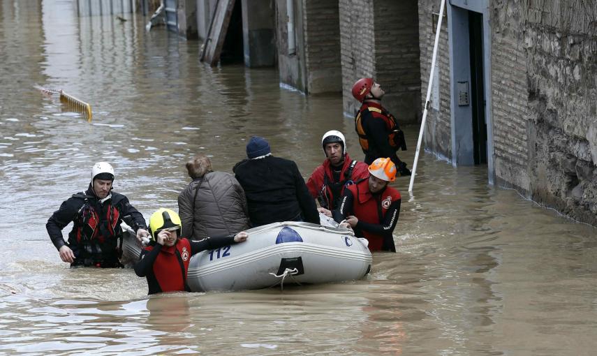 Miembros de la Cruz Roja y Bomberos evacuan a dos personas mayores de su vivienda que se encontraba completamente rodeada de agua en las calles del Casco Viejo de Tudela. /Jesús Diges (EFE)