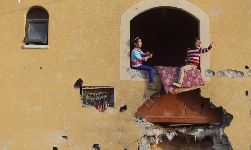 Dos niñas palestinas juegan en su casa, que quedó prácticamente derruida durante la operación 'Margen Protector' llevada a cabo por Israel el pasado verano. / REUTERS