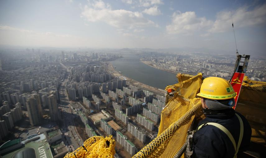 Un albañil observa las vistas desde la planta 99 de la torre Lotte World en Seúl, que actualmente se encuentra en construcción. / REUTERSUn albañil observa las vistas desde la planta 99 de la torre Lotte World en Seúl, que actualmente se encuentra en cons