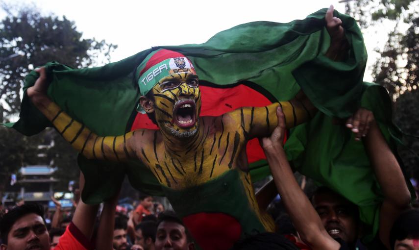 Aficionado al cricket en Bangladesh sotiene la bandera de su país. / AFP