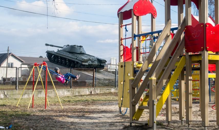 Un tanque pasa junto a un parque infantil en Kagarlyk, Ucrania. / AFP